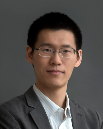 Yuan Yang headshot: an Asian man with short dark hair and wire frame glasses looks seriously at the camera. He is wearing a dark gray suit and white shirt.