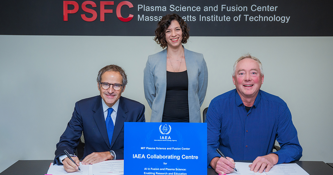Three people smiling as they look at a camera with a sign in front of them and the PSFC logo behind them