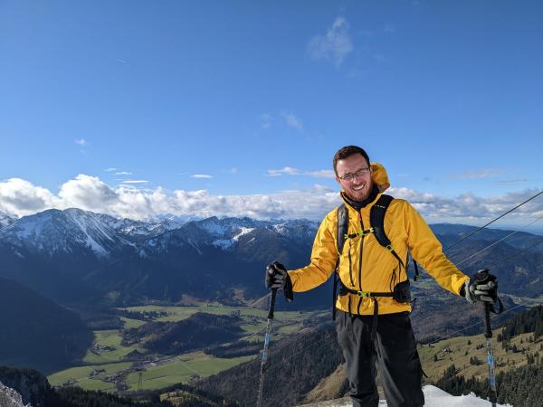 Sciortino atop mountain in yellow jack, blue skies