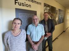 Three researchers standing in hallway.