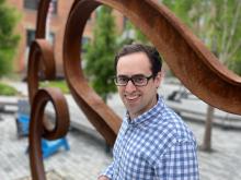 Photo of Noah Mandell with sculpture on MIT campus